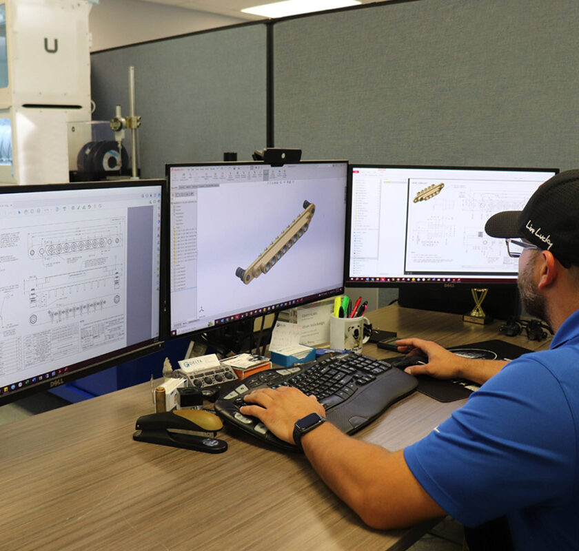 A Delta engineer using 3 monitors to design gang mounts.