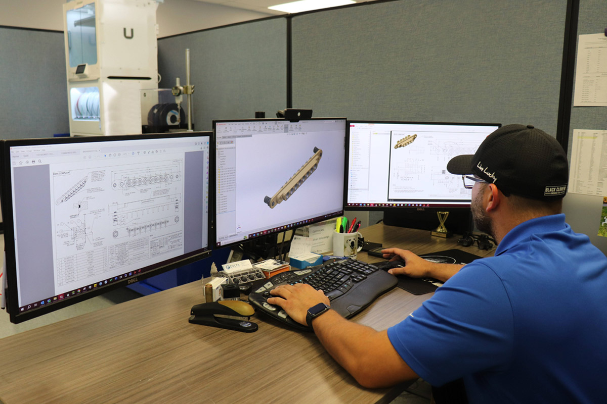 A Delta engineer using 3 monitors to design gang mounts.