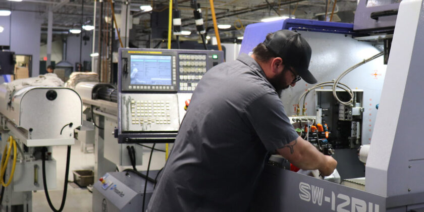 A Delta team member working at our multi-axis CNC machine.