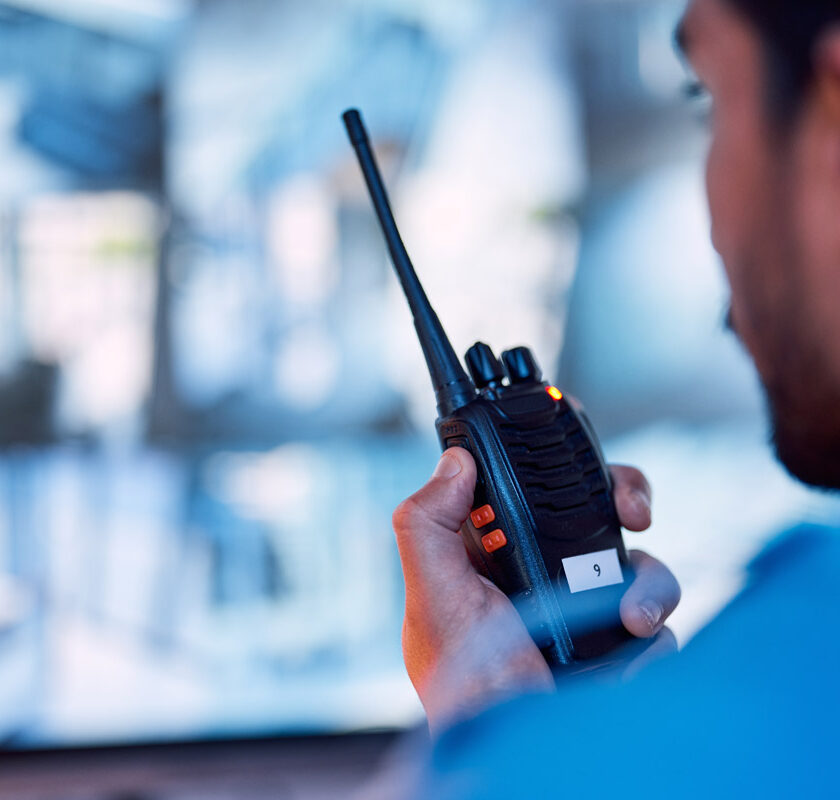 A security guard using a two-way radio to communicate.